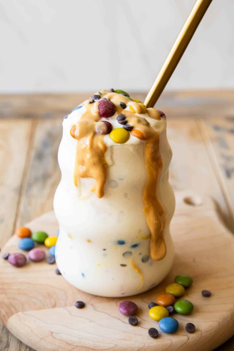 Angled photo of Monster Cookie Protein Frosty with chocolate candies and peanut butter.