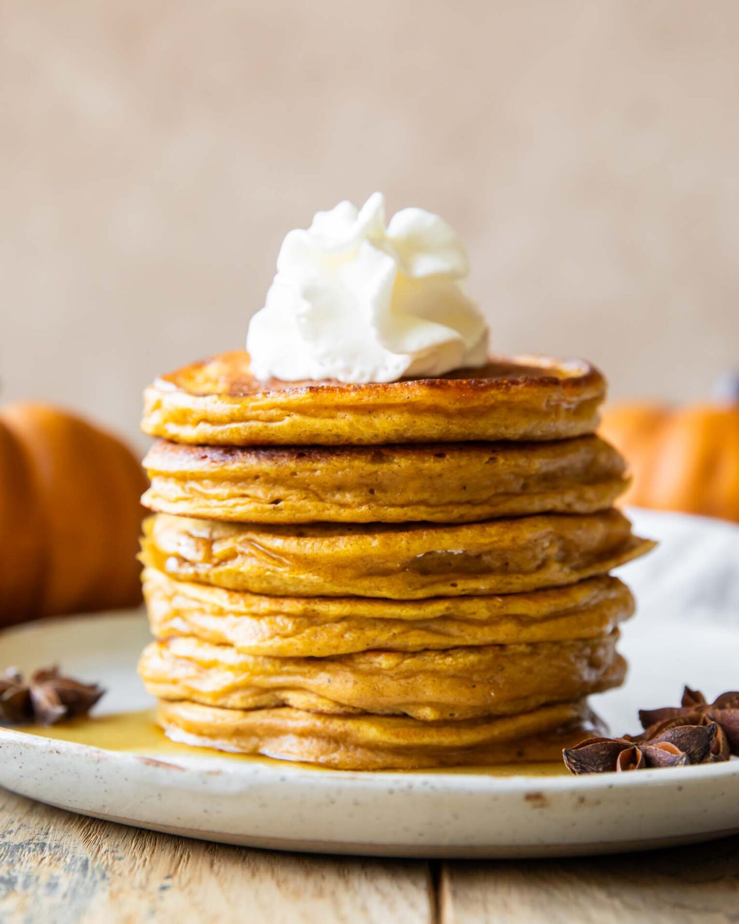 Across photo of Pumpkin Protein Pancakes recipe stacked on a plate.