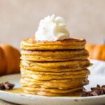 Across photo of Pumpkin Protein Pancakes recipe stacked on a plate.