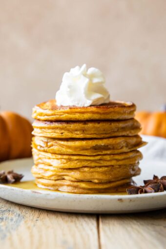 Across photo of Pumpkin Protein Pancakes recipe stacked on a plate.