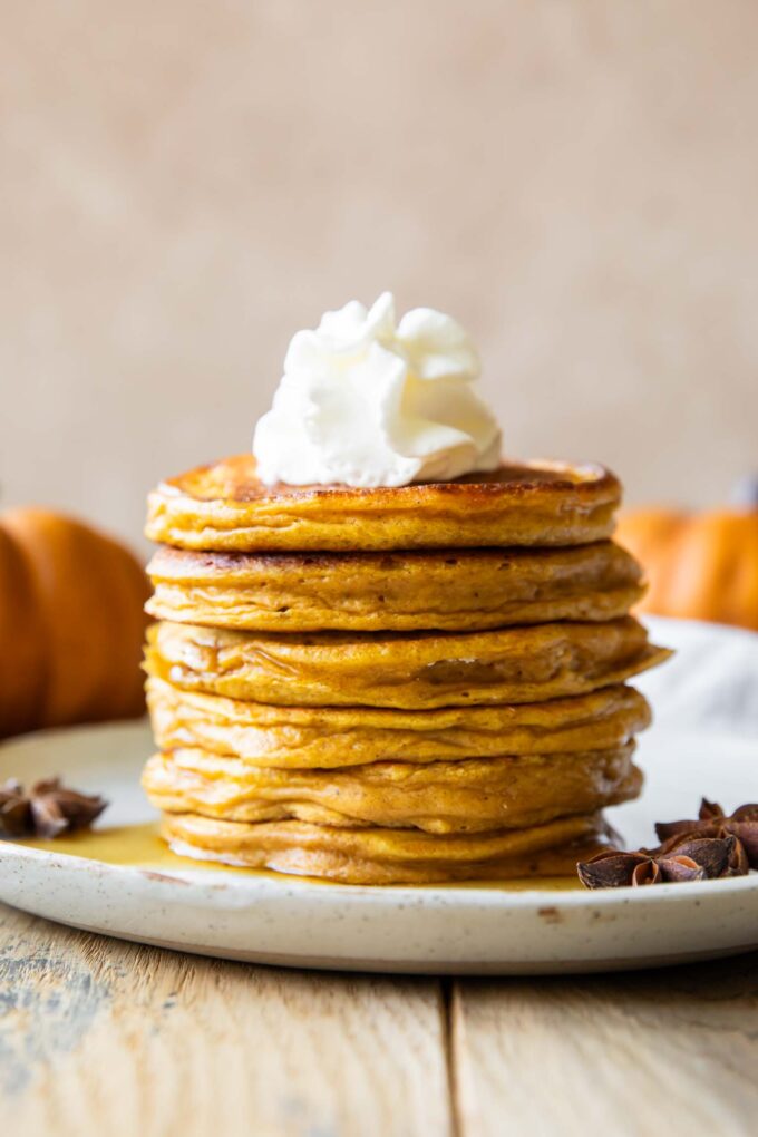 Across photo of Pumpkin Protein Pancakes recipe stacked on a plate.