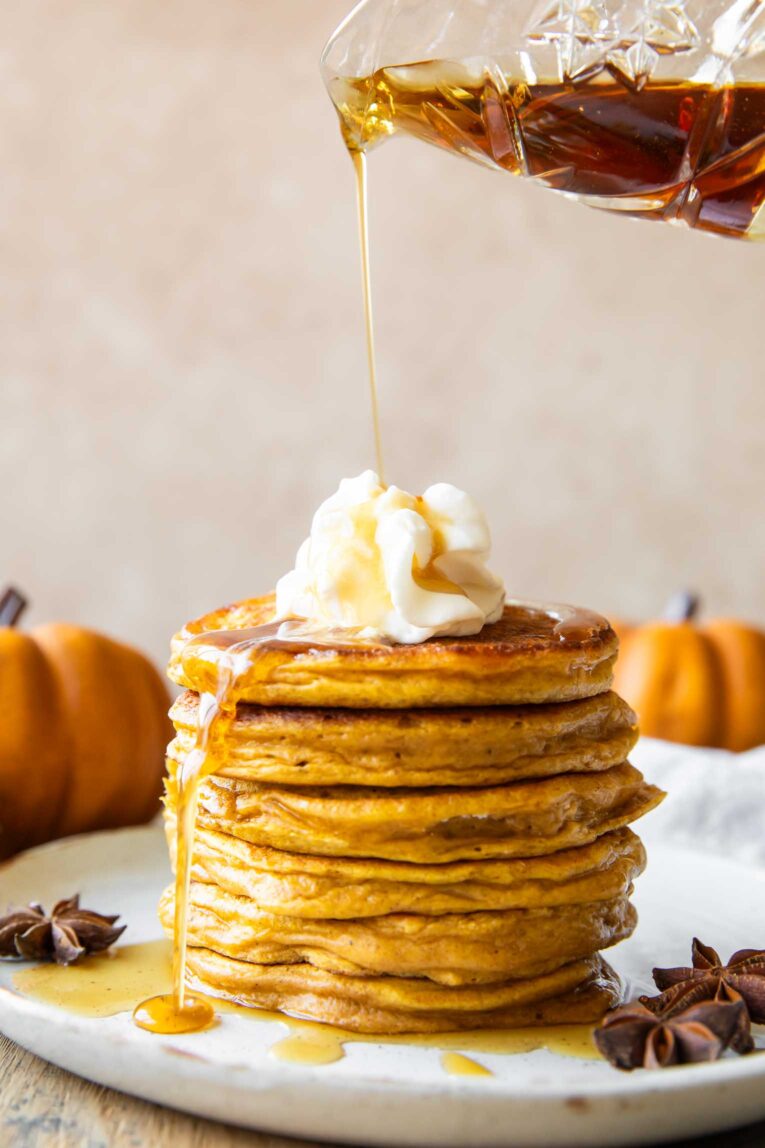 Syrup drizzle over a stack of healthy pumpkin pancakes.