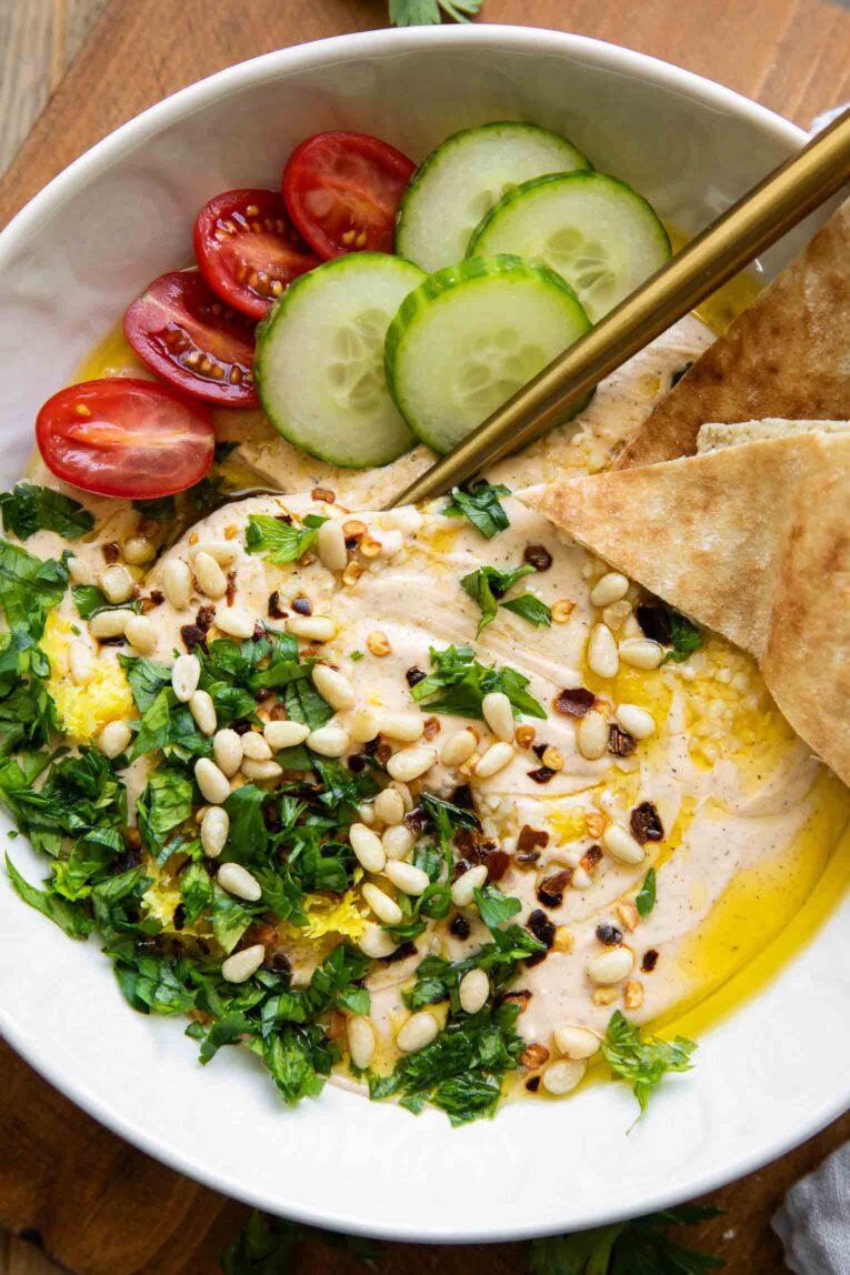 Bowl of Whipped Feta Dip with ingredients and toppings.