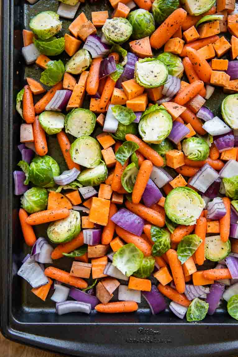 Raw fall vegetables on a baking sheet.