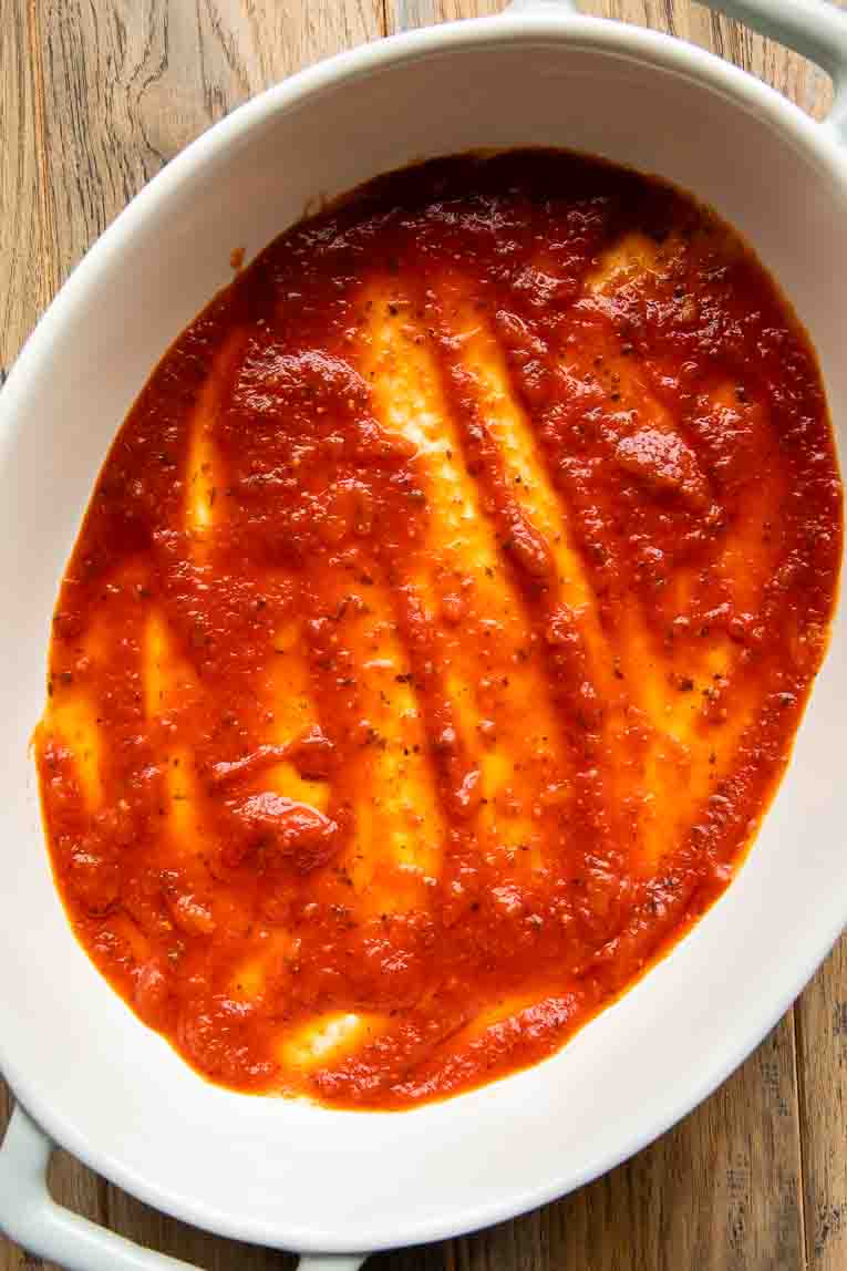 Pasta sauce at the bottom of a casserole dish.