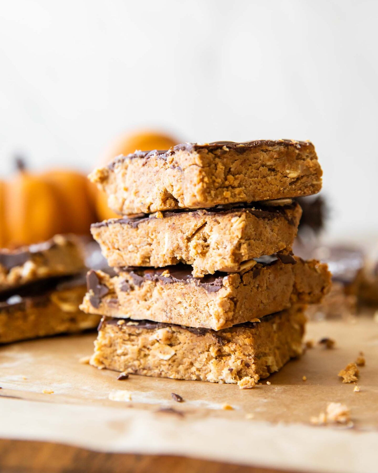 Chocolate Pumpkin Protein Bars stacked on parchment paper.