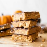 Chocolate Pumpkin Protein Bars stacked on parchment paper.