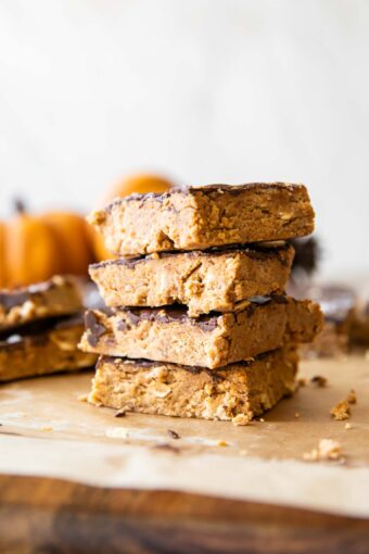Chocolate Pumpkin Protein Bars stacked on parchment paper.