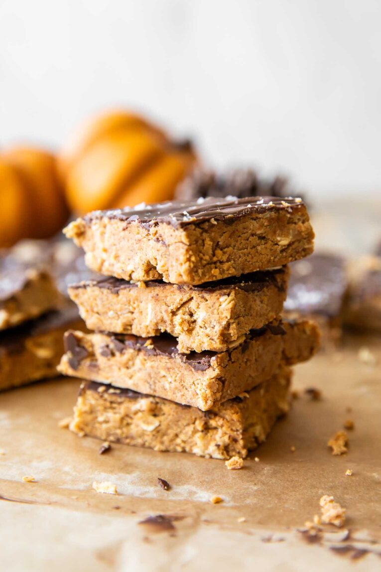 Angled photo of pumpkin chocolate protein bars that are stacked.