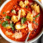 The BEST easy tomato soup recipe in a bowl with basil and croutons.