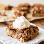 Pecan Pie Bar on a plate with whipped cream.