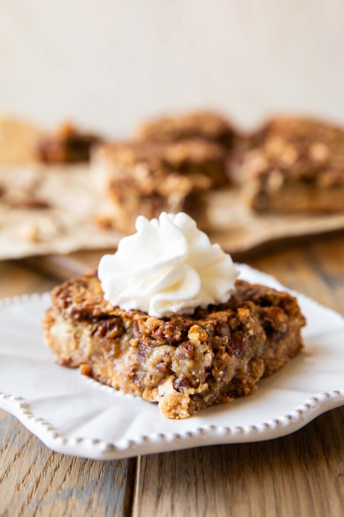 Pecan Pie Bar on a plate with whipped cream.