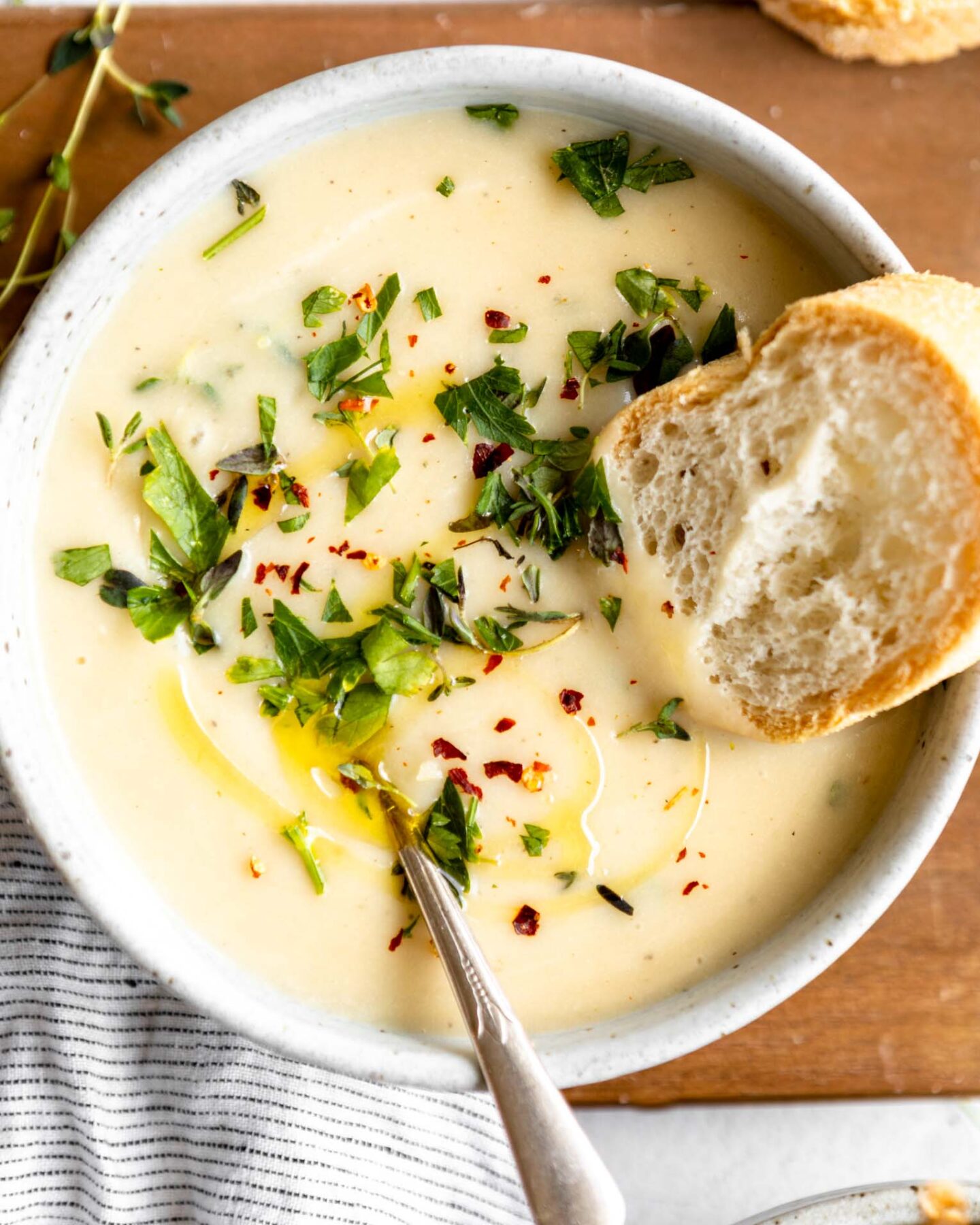 Top shot photo of Potato Leek Soup with garnish and bread.