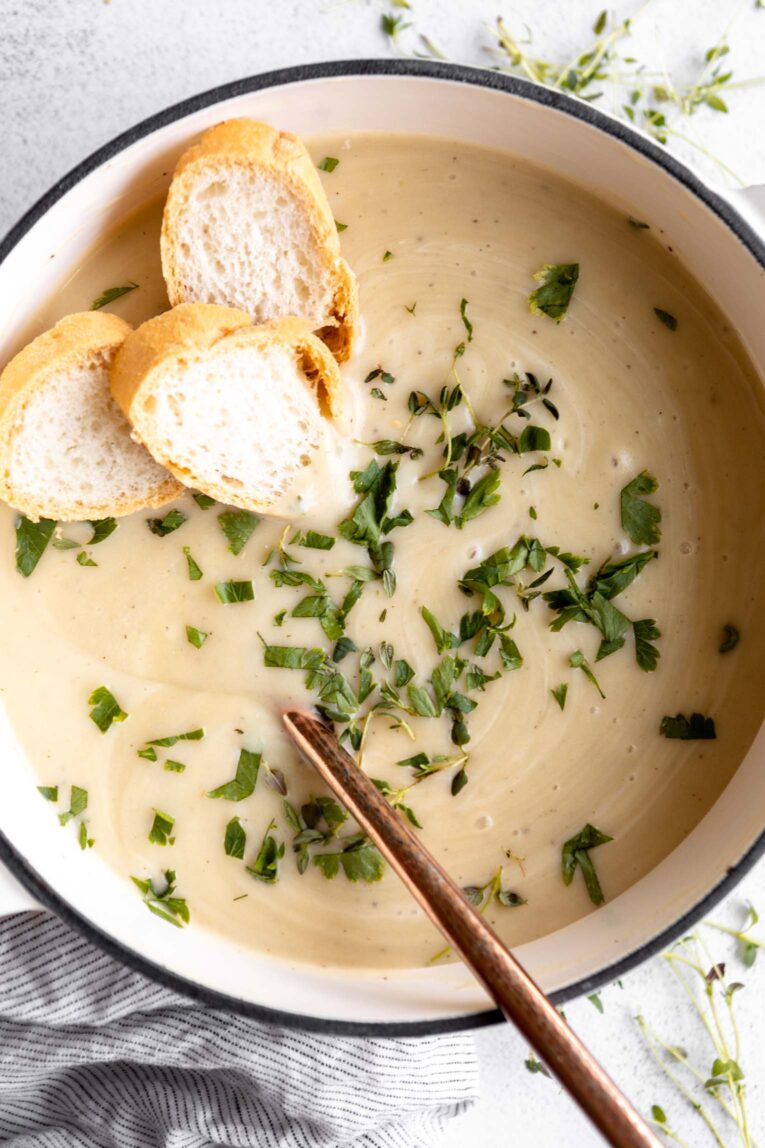 Potato Leek Soup in a dutch oven with thyme and fresh bread.