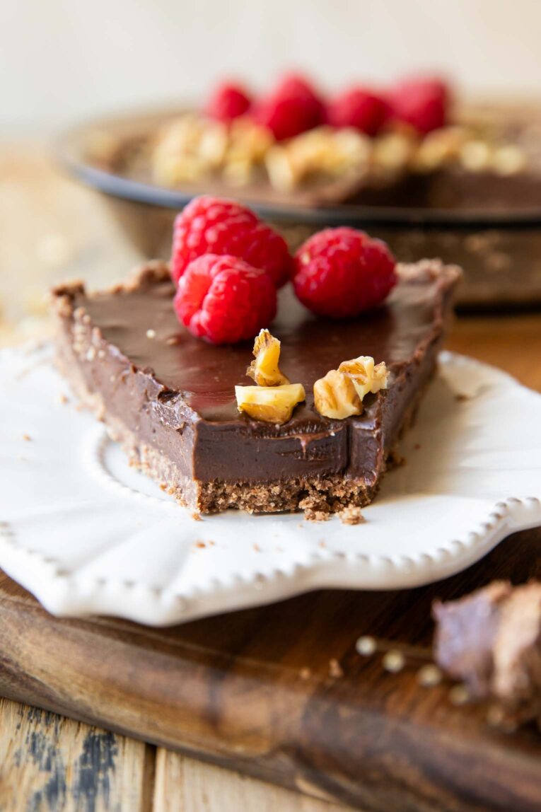 Across photo of Nutella Chocolate pie recipe with raspberries and bite taken out.