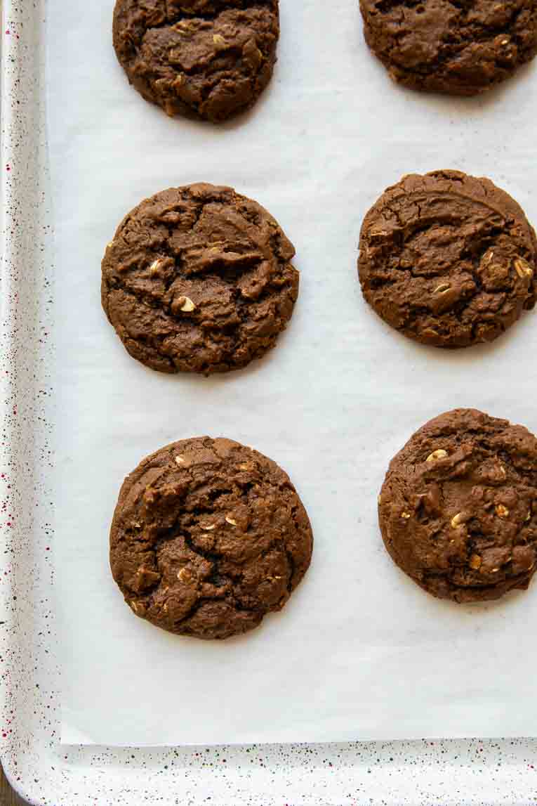 Freshly baked molasses cookies on a baking sheet.