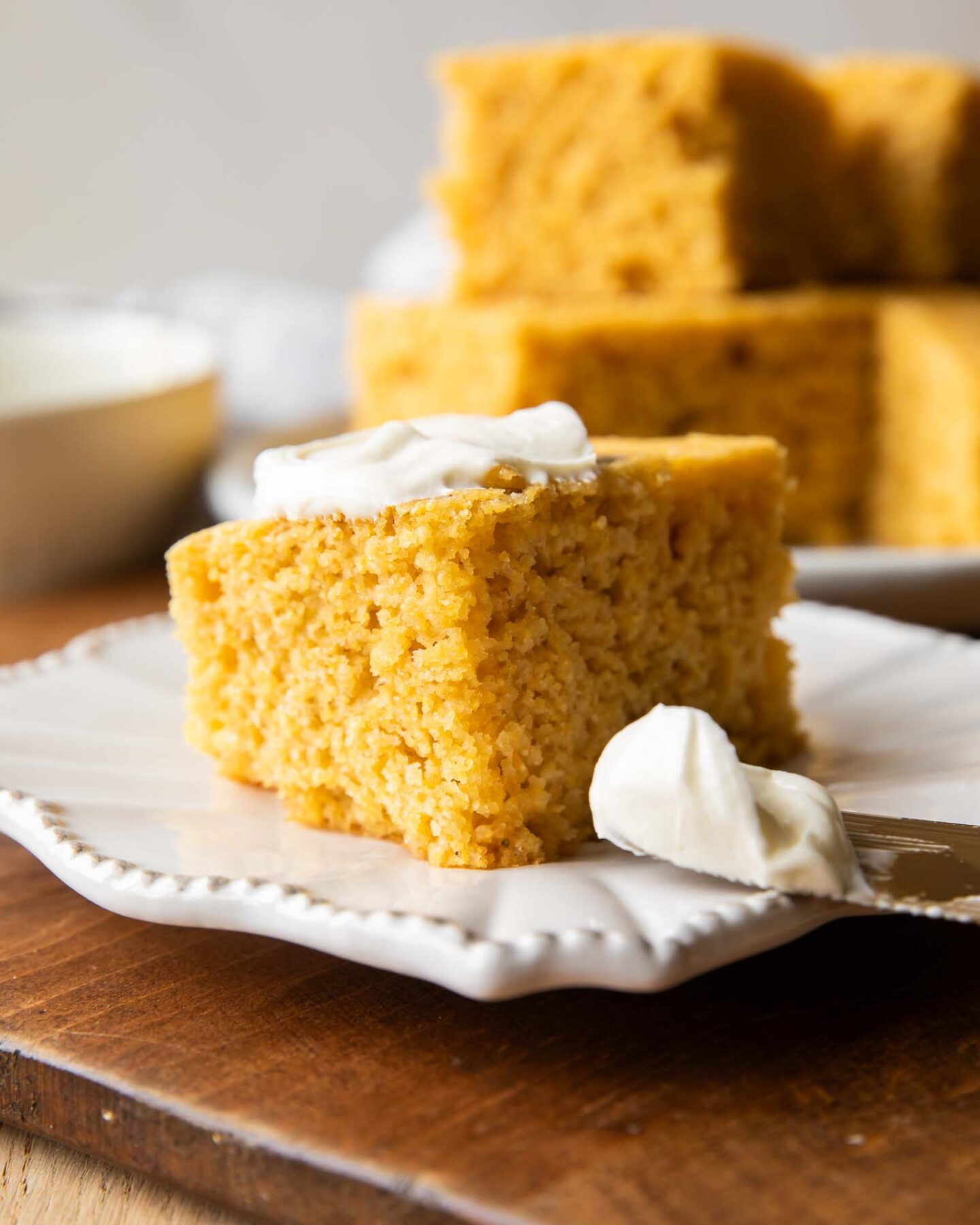 Slice of Cornbread on a plate with butter.