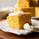Slice of Cornbread on a plate with butter.