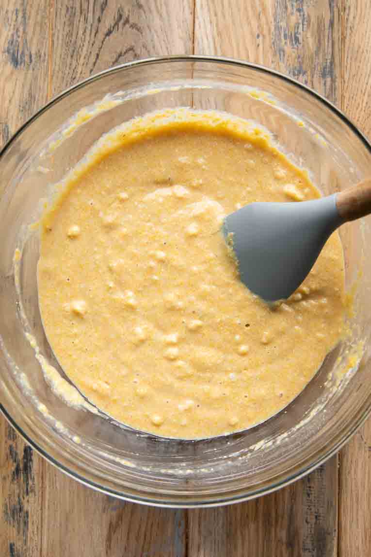 Cornbread batter being mixed in a bowl.