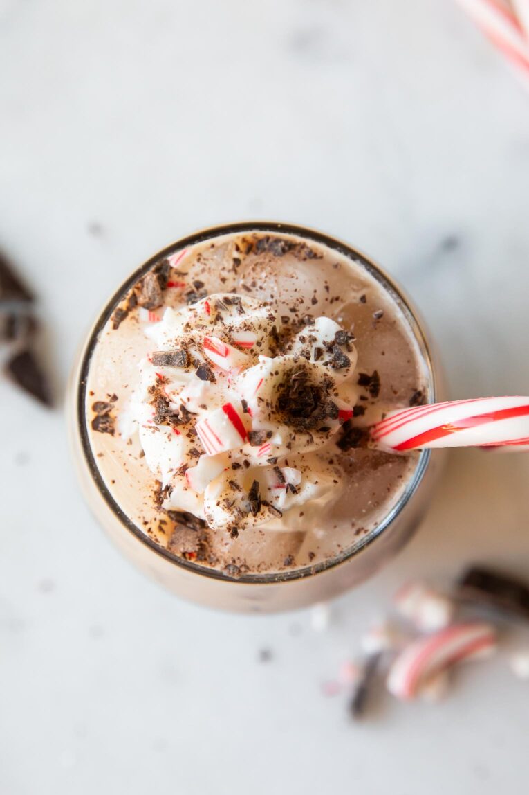Top shot of Iced Peppermint Mocha with whipped cream, candy cane, and chocolate.
