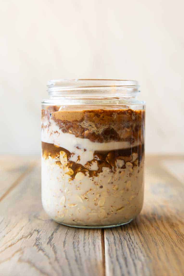 Ingredients for Oatmeal Cookie Overnight Oats layered in a jar.