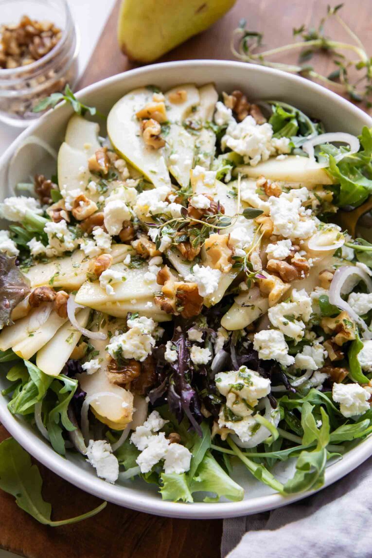 Angled photo of Pear & Goat Cheese Salad with shallots.