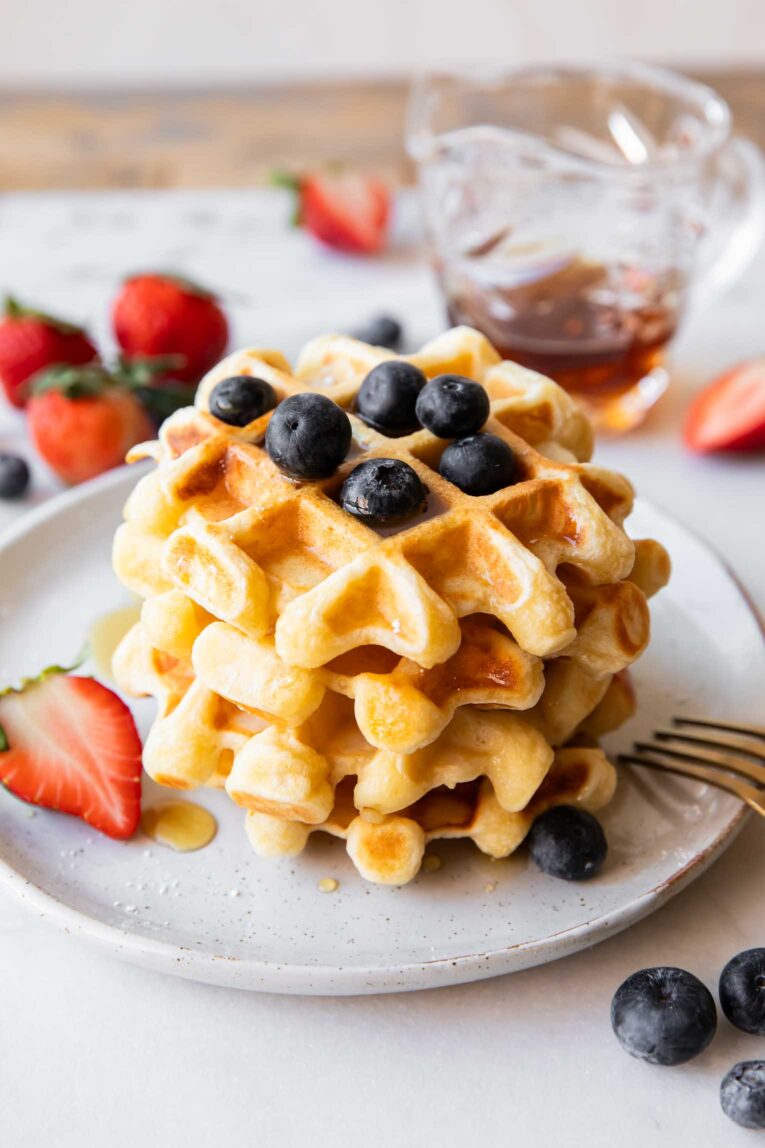 Angled photo of Cottage Cheese Waffles recipe with berries on top.