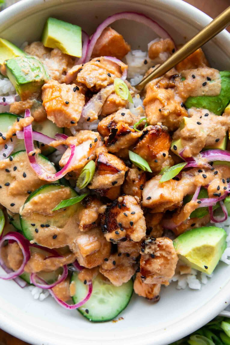 Close up of miso salmon recipe with rice, cucumber, and other toppings.