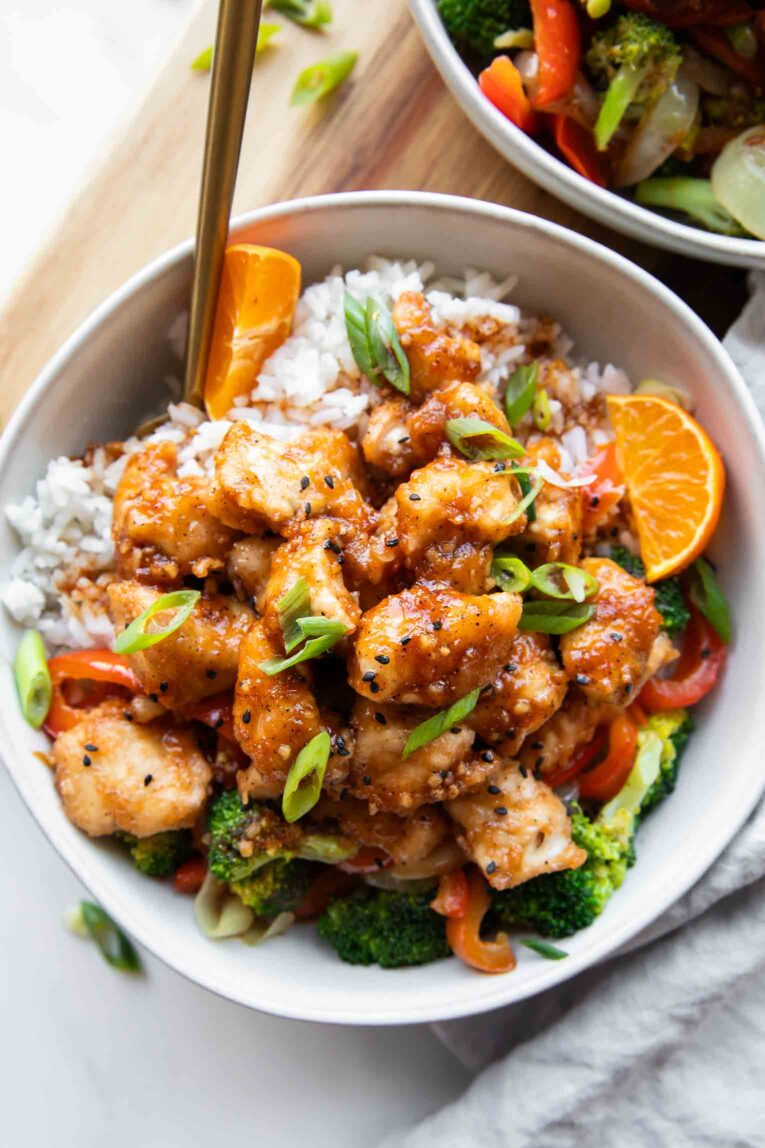 Top shot of orange chicken in a meal prep bowl with rice and veggies.