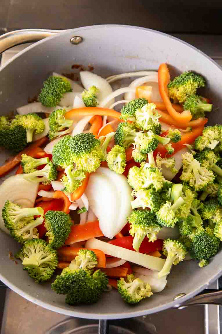 Veggies being stir fried in a pan.