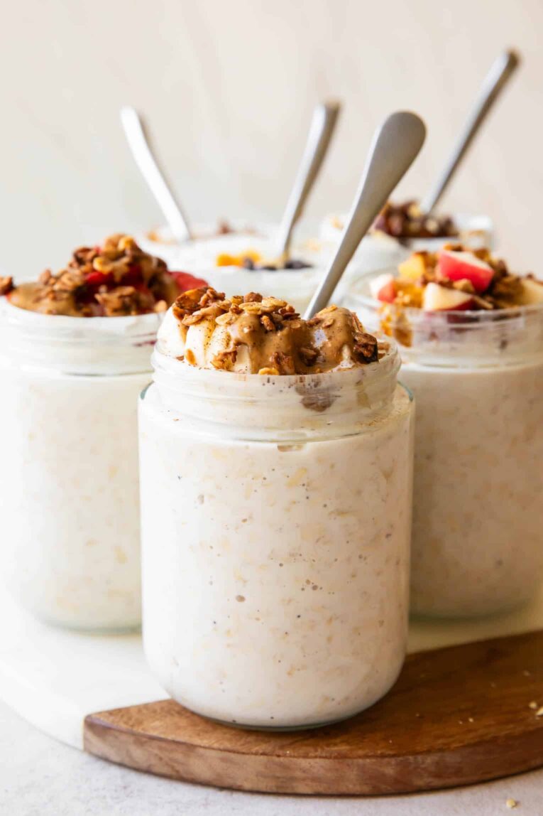 Across photo of overnight oats in jars with spoons and different toppings.
