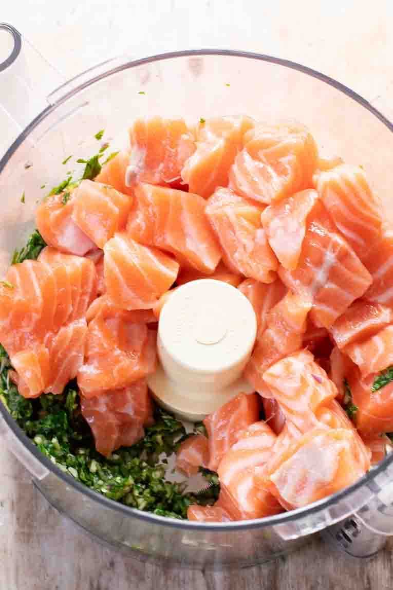 Salmon cubes added to a food processor.