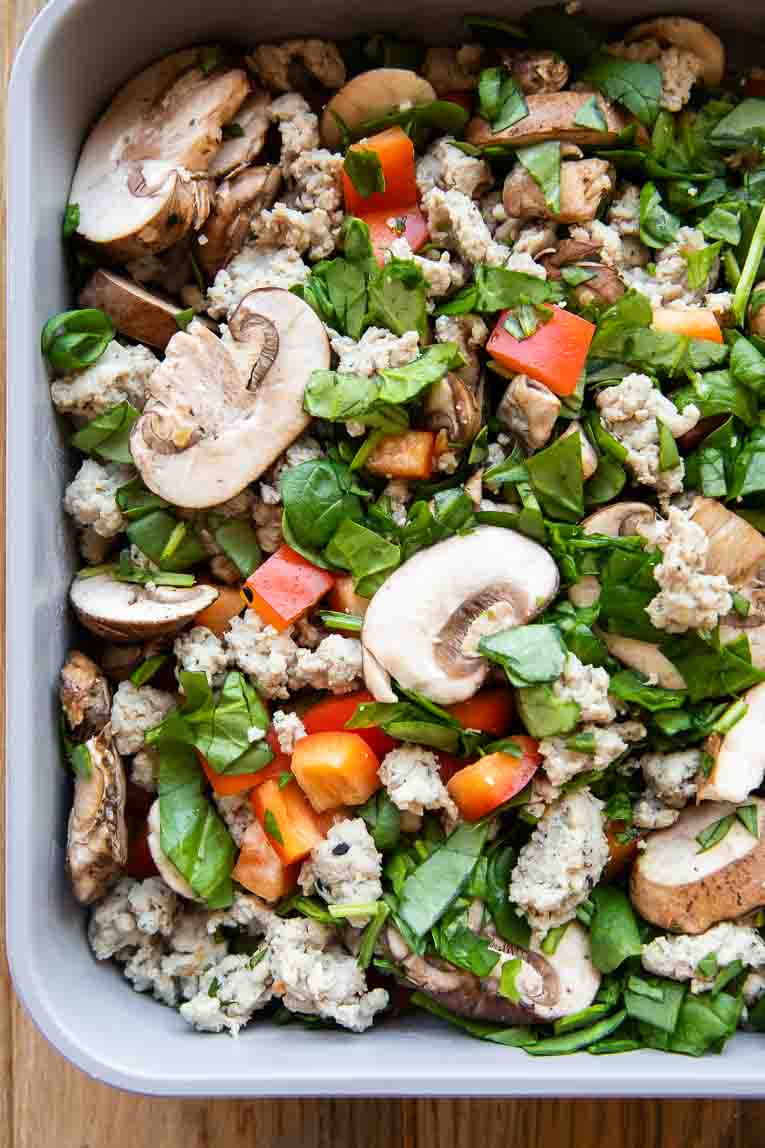 Veggies and ground beef in a casserole dish.