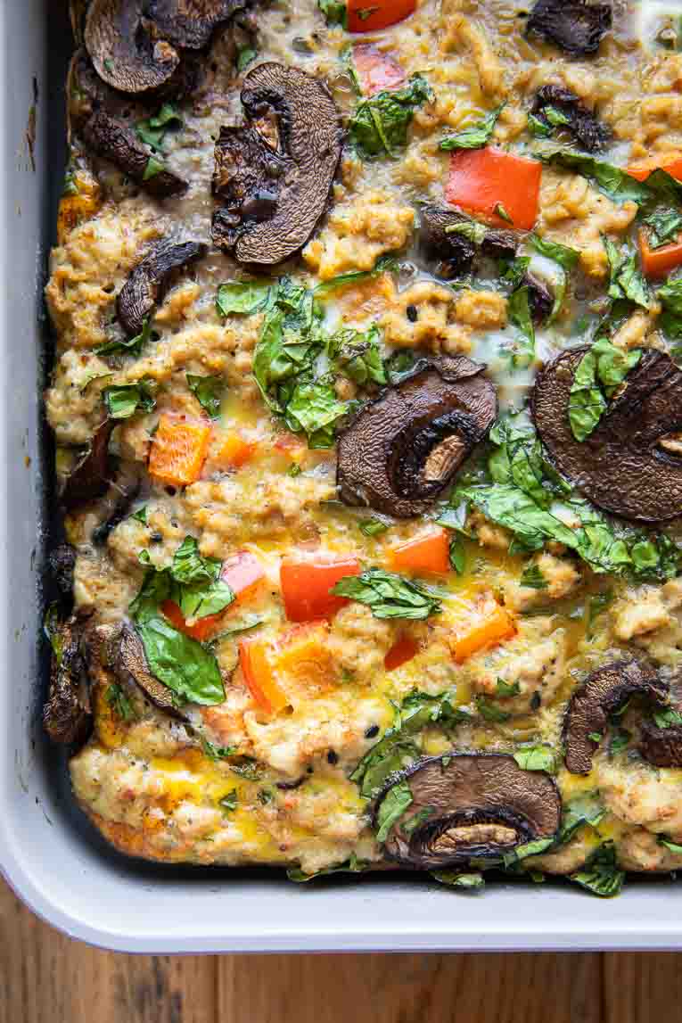 Eggs poured over veggies and ground beef in a casserole dish for egg bake.