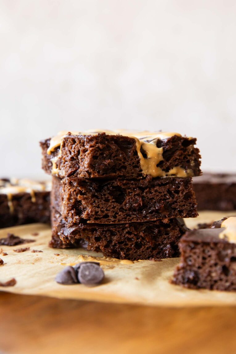 Cottage Cheese Brownies stacked on parchment paper.