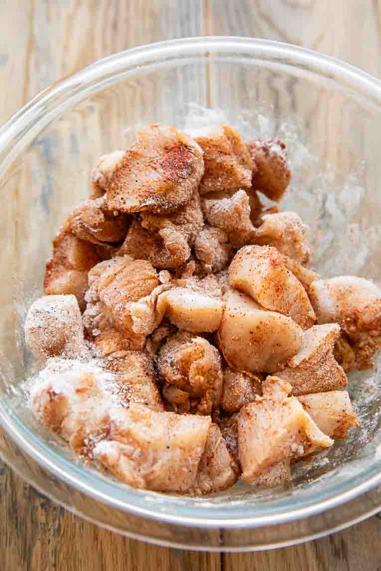 Cubed chicken mixed with tapioca breading in a bowl.