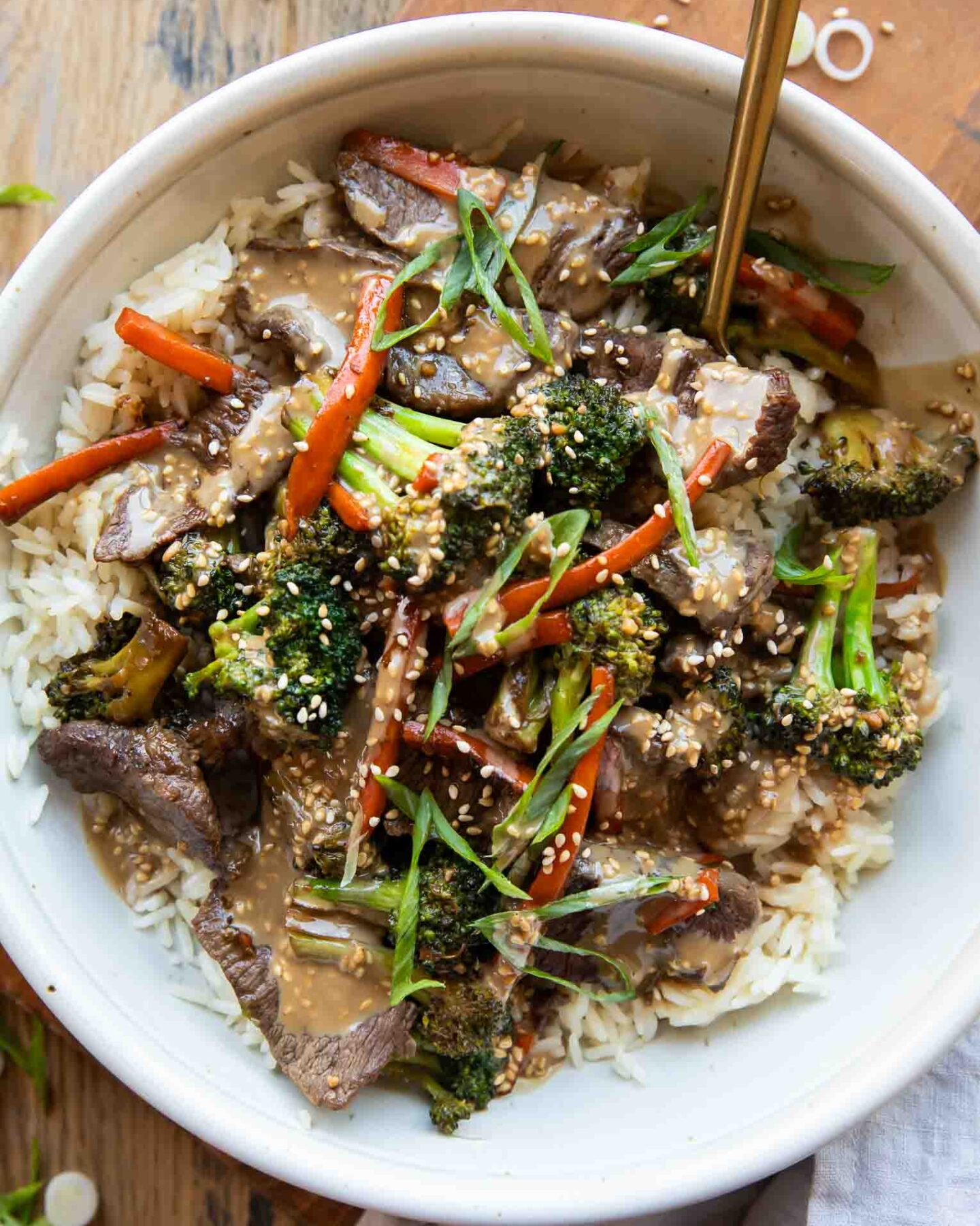 Easy beef and broccoli bowl recipe on a wood table.