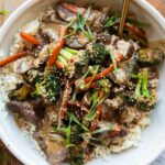 Easy beef and broccoli bowl recipe on a wood table.