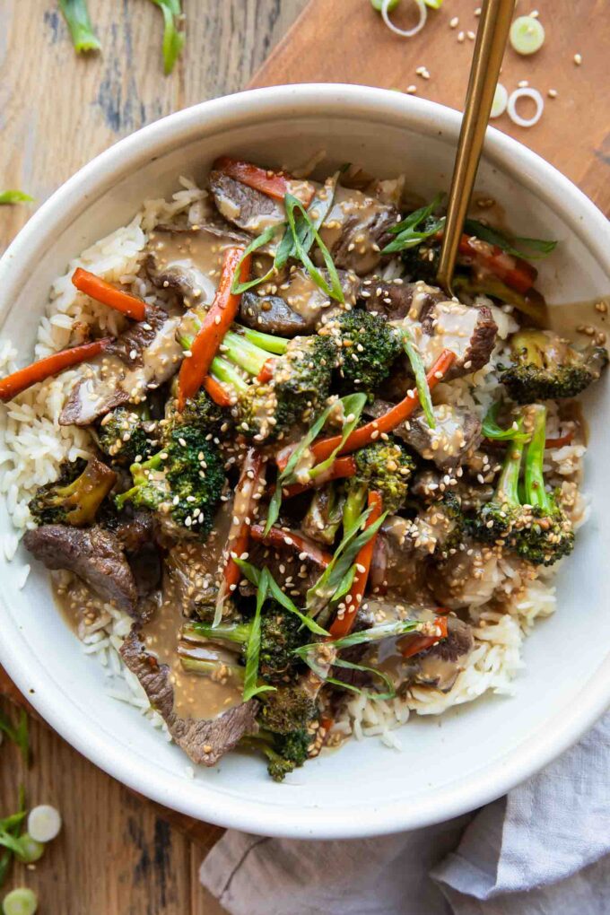 Easy beef and broccoli bowl recipe on a wood table.