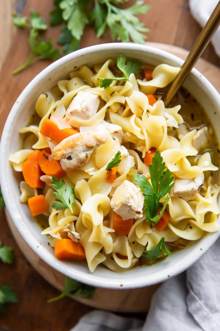 Close up of homemade Chicken Noodle Soup in a bowl with parsley.