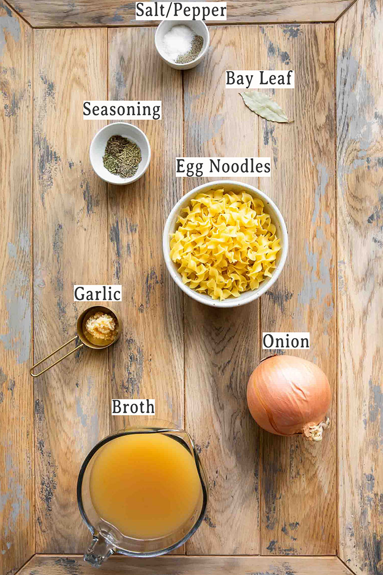Ingredients for noodle soup recipe on a wood board.
