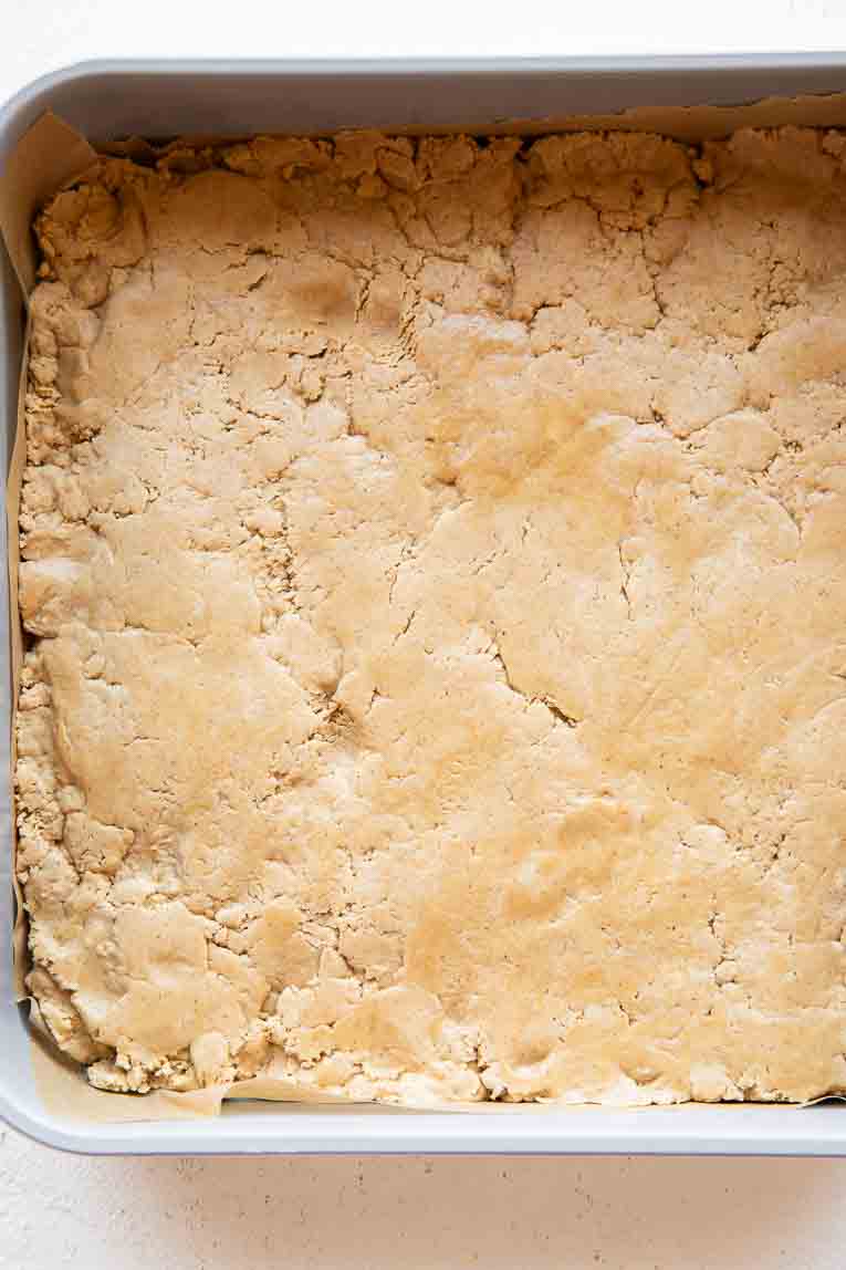 Peanut butter protein bar mixture pressed into pan.