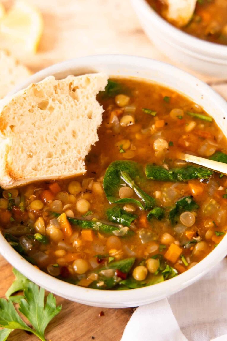 Angled photo of lentil soup with bread.