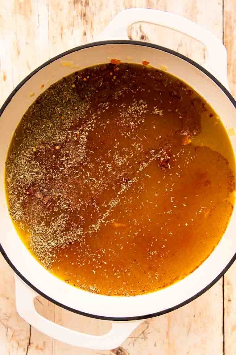 Broth and lentils for lentil soup in a Dutch oven.