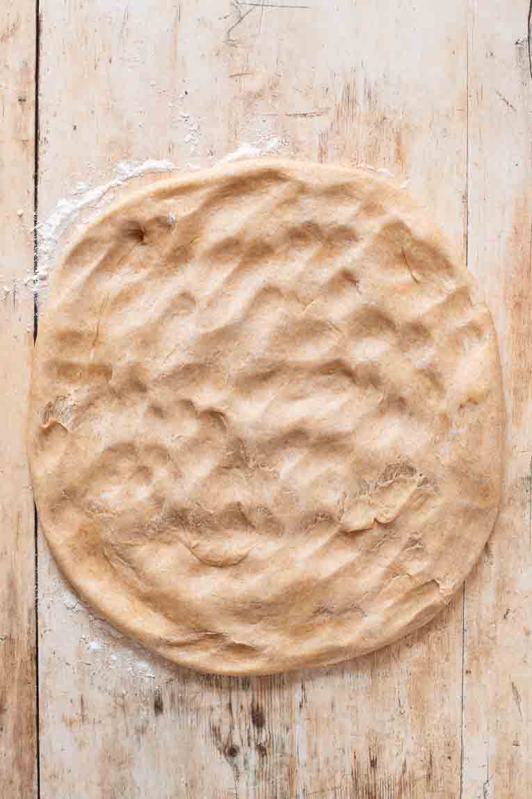 Bread dough rolled onto surface.