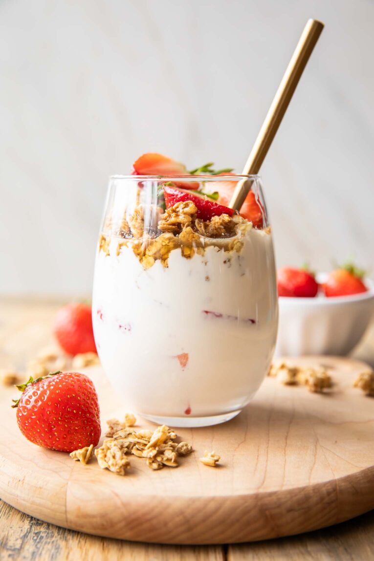 Strawberry Cheesecake Breakfast Parfaits recipe in a glass with fresh strawberries.