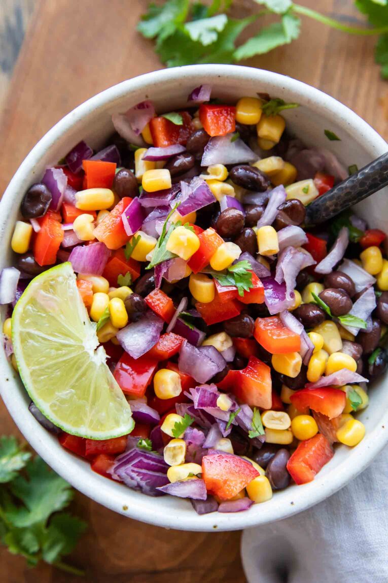 Black bean and corn salad in a bowl with lime.
