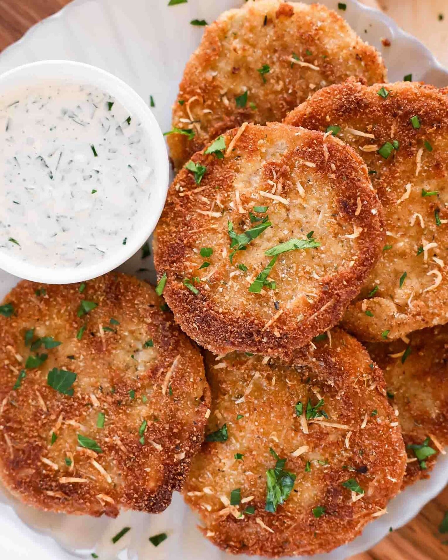 Fried Green Tomatoes on a plate with creamy dipping sauce.