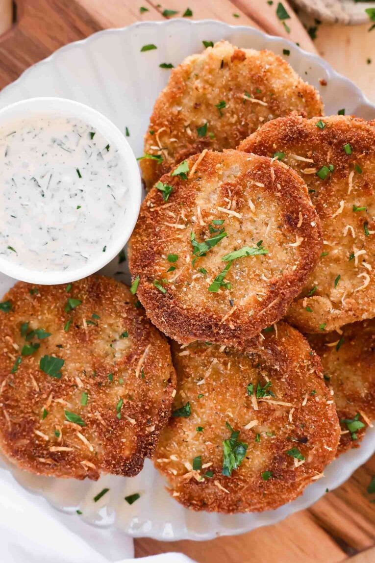 Fried Green Tomatoes on a plate with creamy dipping sauce.