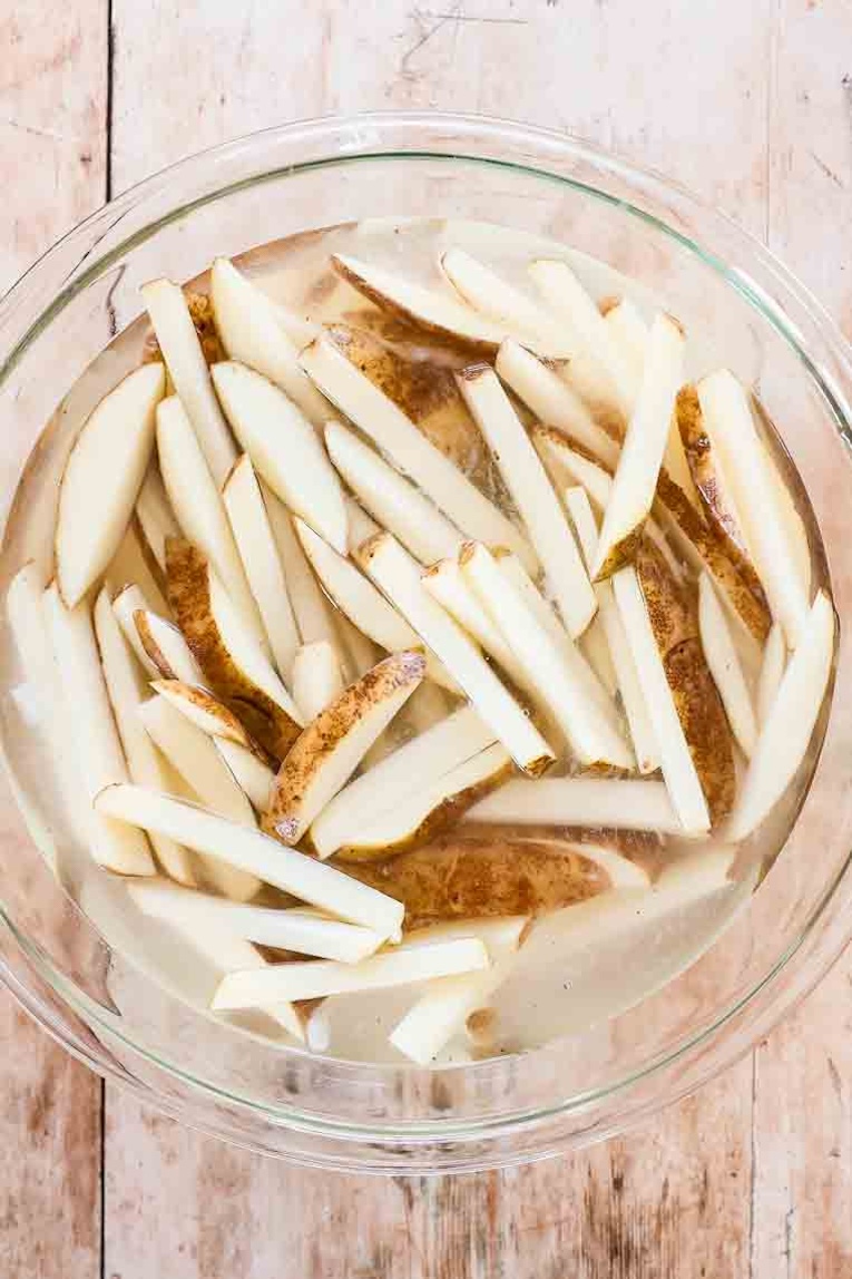 Sliced potato fries soaked in a bowl.
